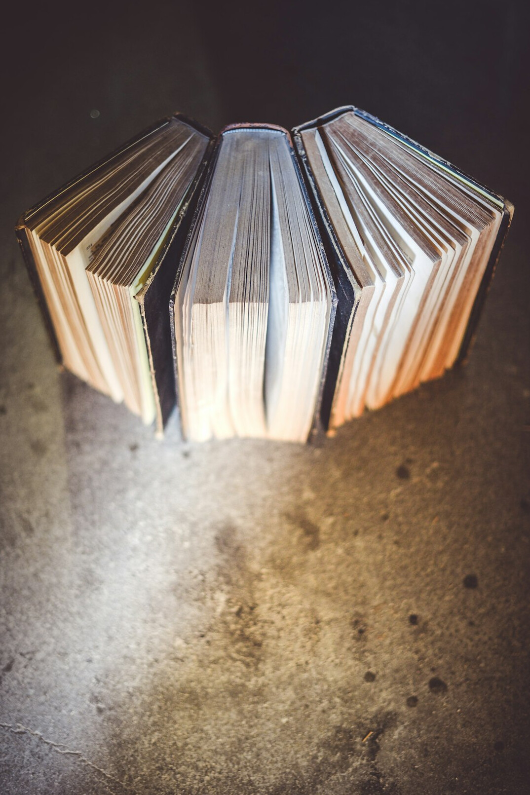 Open books stacked on a table with warm light